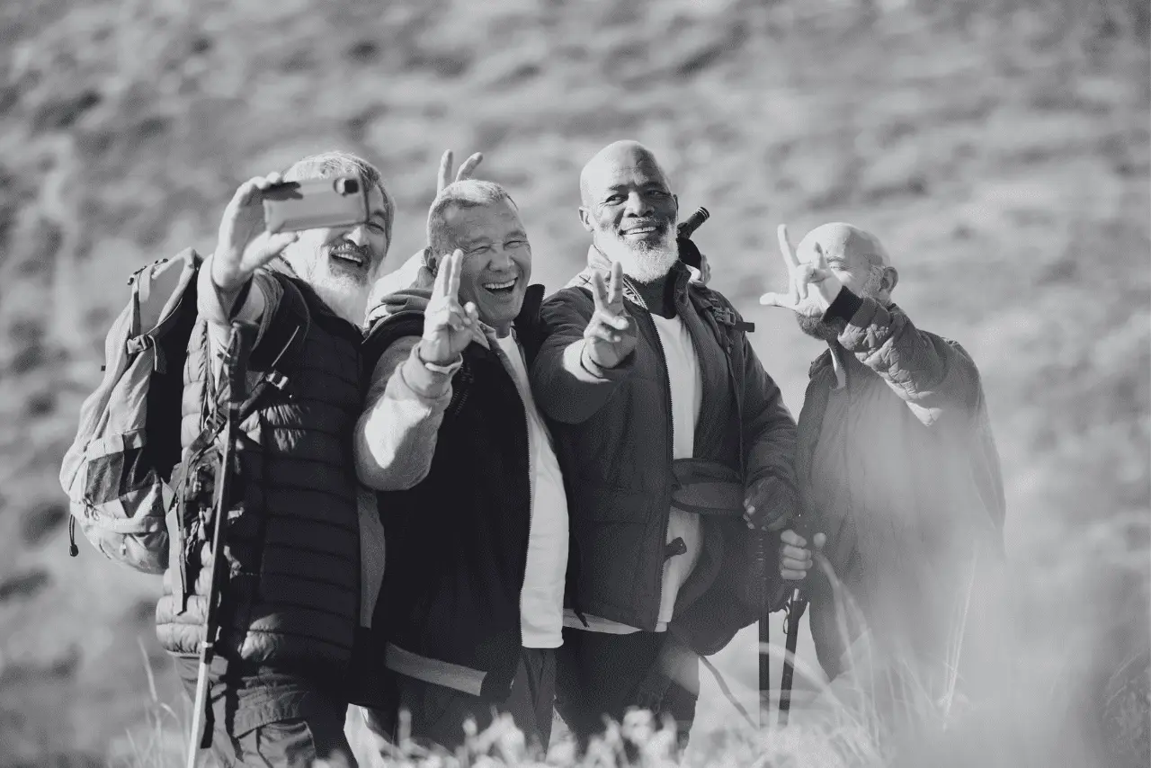 Group of four senior men taking a selfie while smiling and hiking