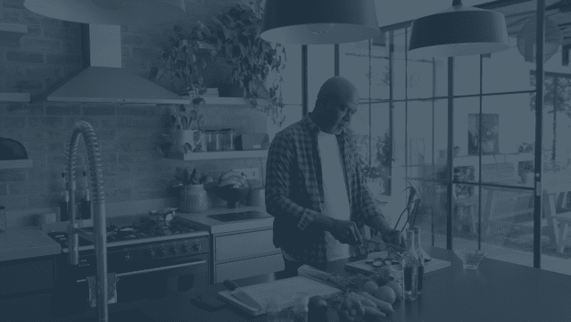 Retired man cutting vegetables in his kitchen
