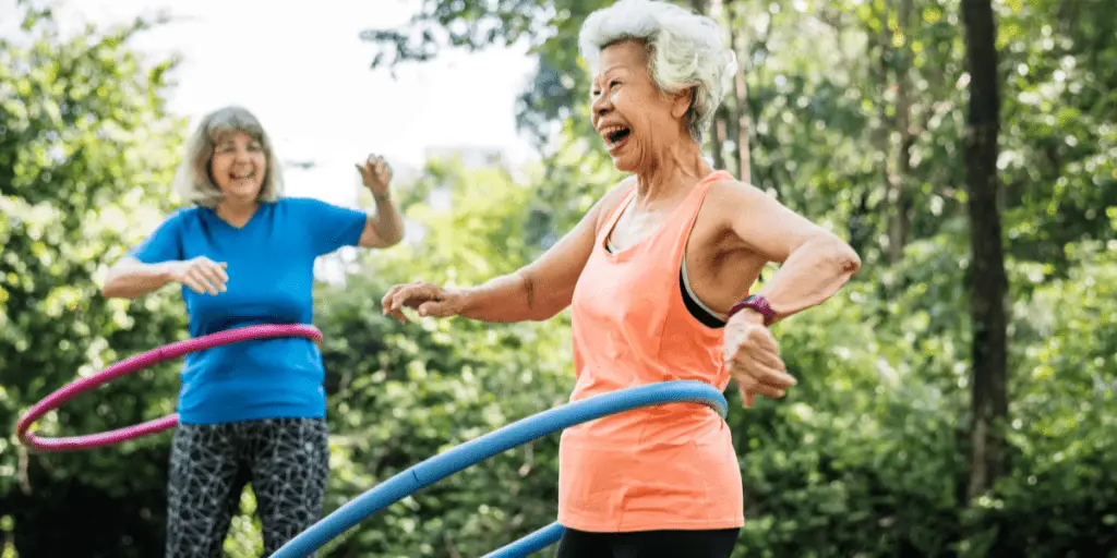 Retired Women Laughing While Hula Hooping