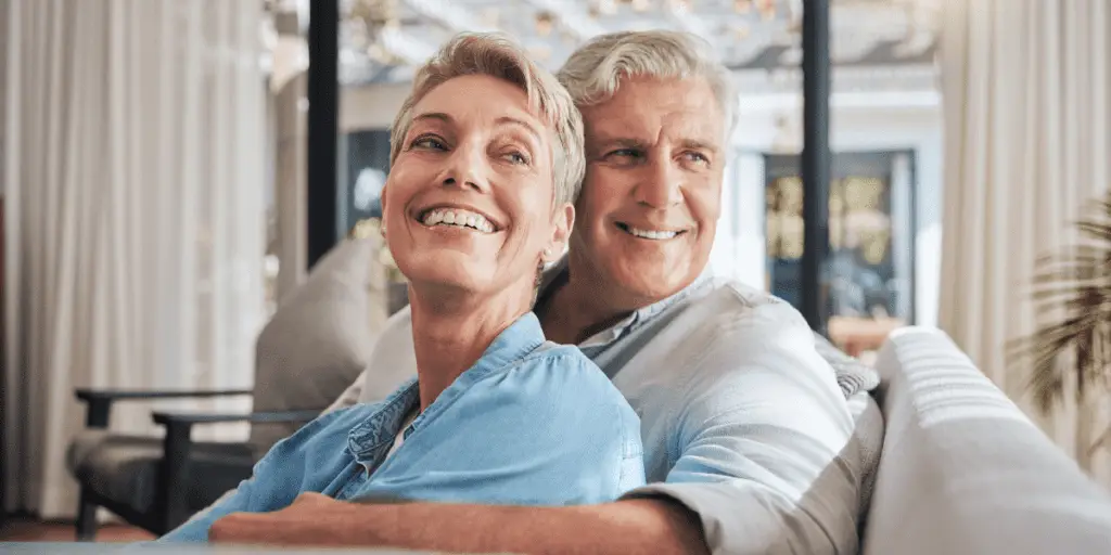 Smiling Retired Couple On Couch