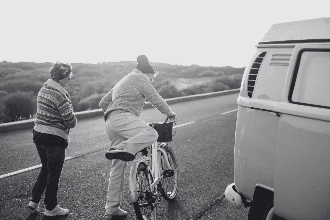 Retired Couple riding bicycle outside of VW van