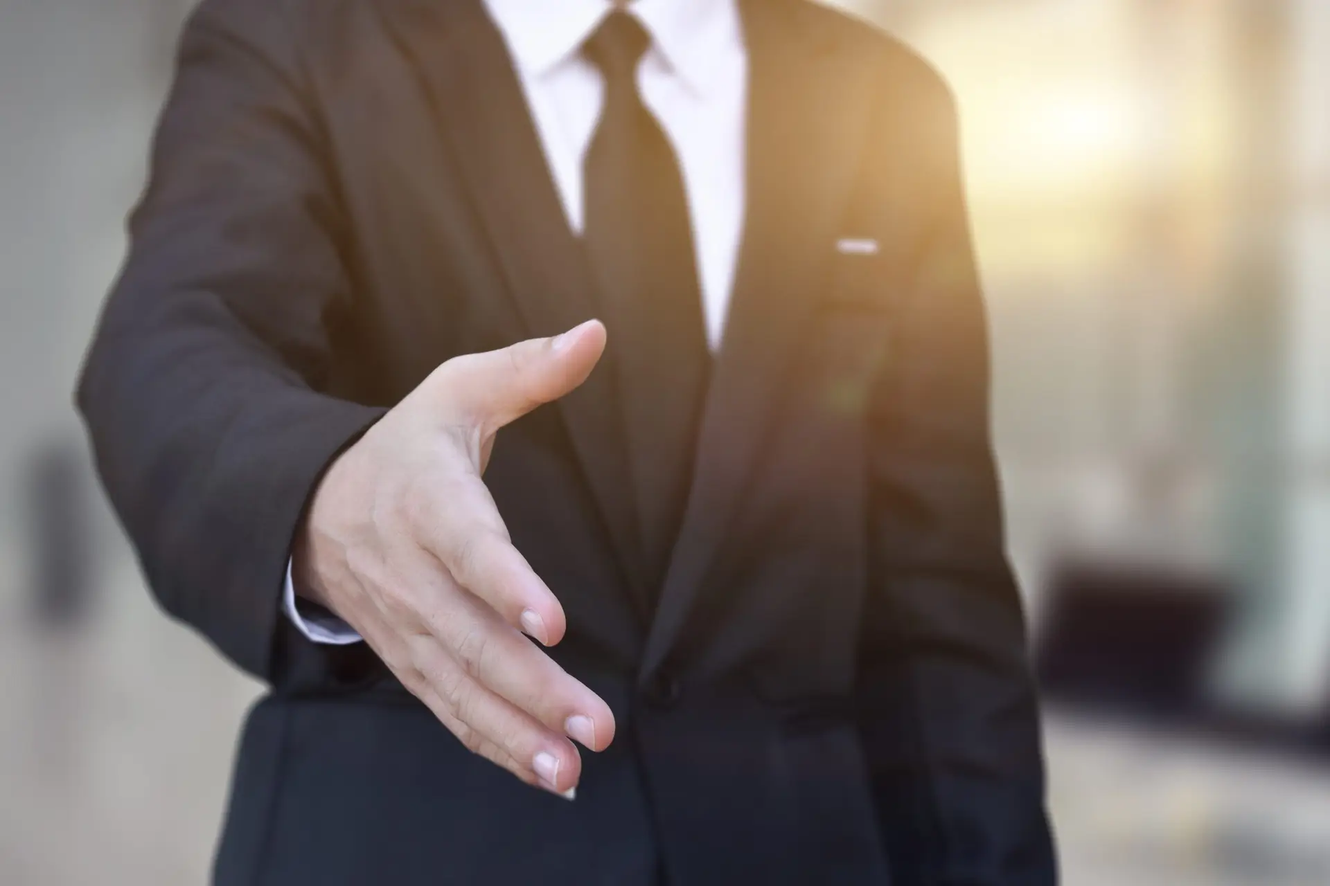 Businessman in suit holding out hand to shake